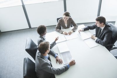 Four business people sitting around a table and having a business meeting